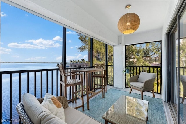 sunroom featuring a water view