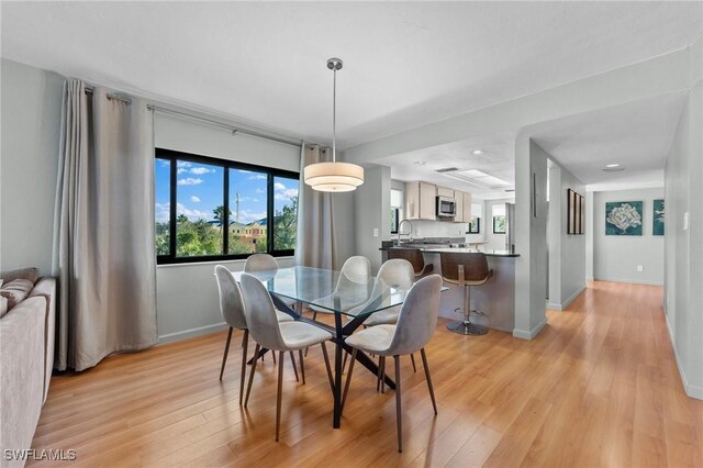 dining room featuring light wood-type flooring and baseboards