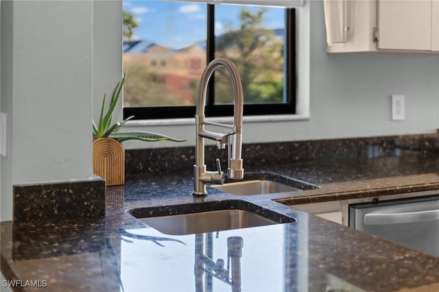 kitchen with stainless steel dishwasher, white cabinetry, and a sink