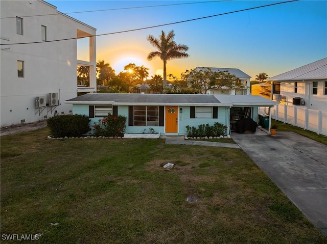 view of front of home with a carport and a lawn