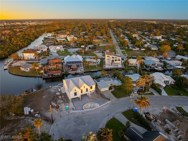 aerial view at dusk featuring a water view