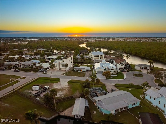 aerial view at dusk featuring a water view