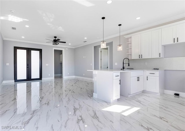 kitchen with pendant lighting, sink, white cabinets, crown molding, and french doors