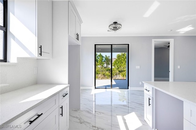 kitchen with white cabinetry, light stone counters, crown molding, and decorative backsplash