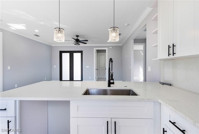 kitchen featuring pendant lighting, sink, white cabinets, ceiling fan, and crown molding