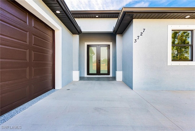 property entrance featuring a garage and french doors