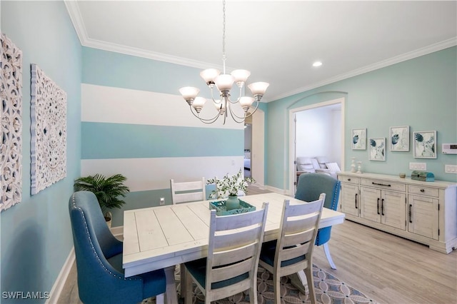 dining room with a notable chandelier, crown molding, and light hardwood / wood-style floors