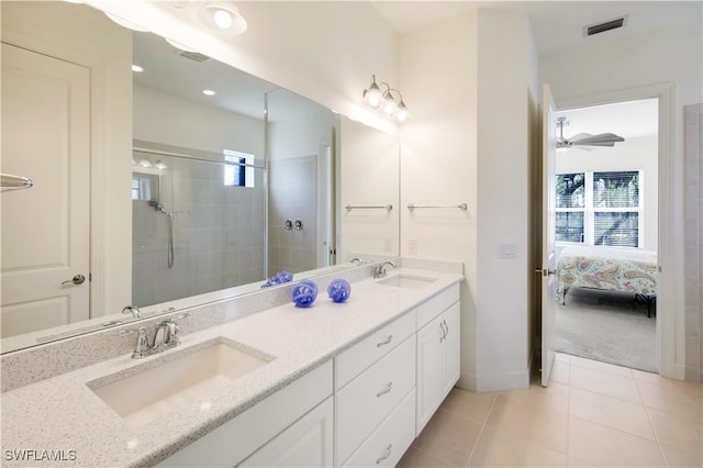 bathroom with vanity, tile patterned flooring, and a tile shower