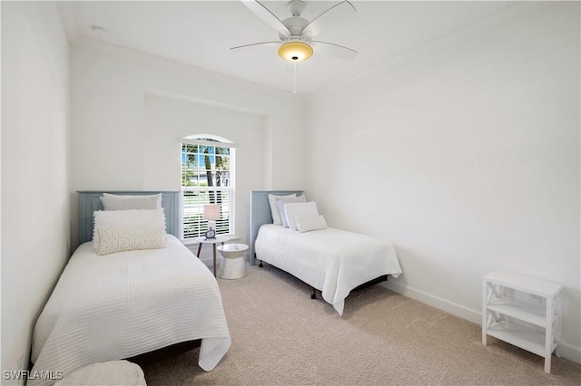 carpeted bedroom with ornamental molding and ceiling fan