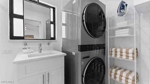 washroom with stacked washer and dryer, a sink, and laundry area