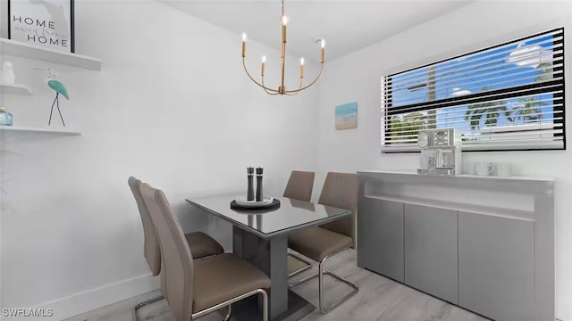 dining area with baseboards and a notable chandelier