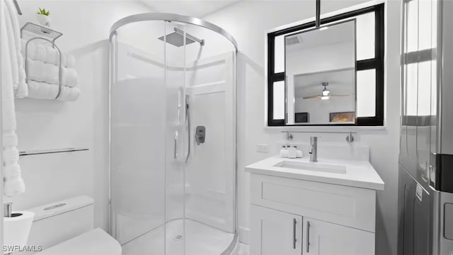 full bathroom featuring a ceiling fan, a shower stall, toilet, and vanity