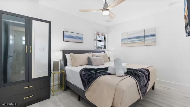 bedroom featuring ceiling fan, light wood-type flooring, and baseboards