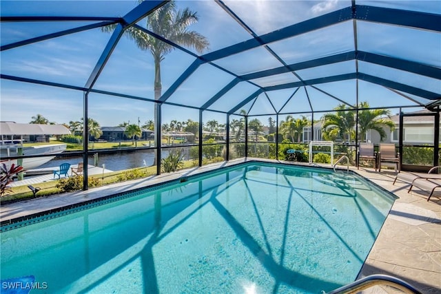 view of pool featuring a patio, a water view, and glass enclosure