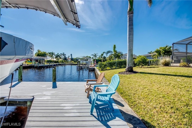 view of dock with a yard, a lanai, and a water view