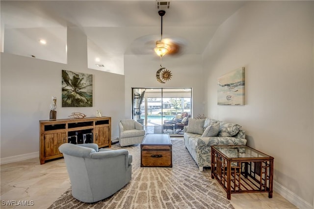 living room with ceiling fan and a high ceiling