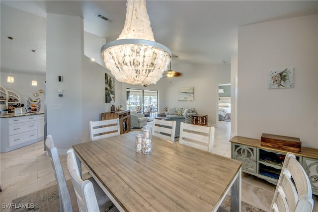 dining space with vaulted ceiling and a notable chandelier