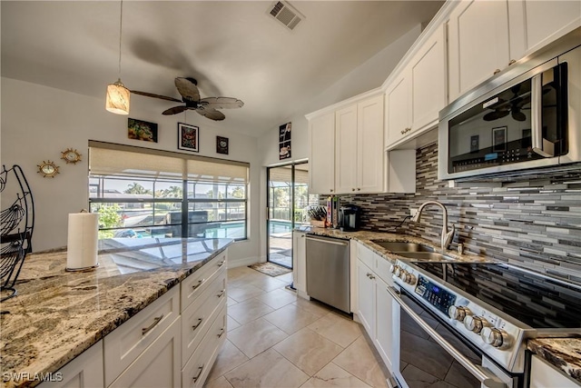 kitchen featuring appliances with stainless steel finishes, tasteful backsplash, sink, white cabinets, and light stone counters