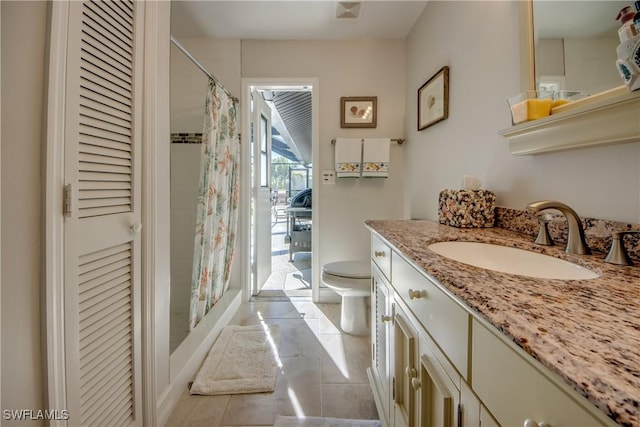 bathroom featuring vanity, tile patterned flooring, toilet, and walk in shower