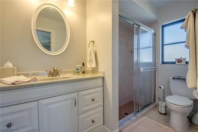 bathroom with vanity, tile patterned floors, a shower with door, and toilet