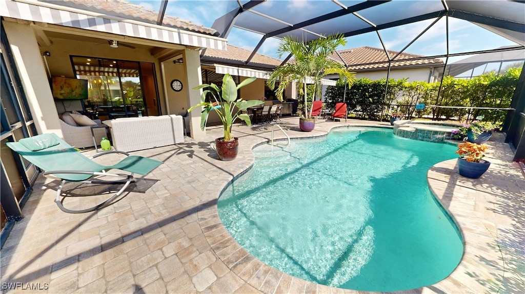 view of swimming pool with ceiling fan, outdoor lounge area, glass enclosure, a patio area, and an in ground hot tub