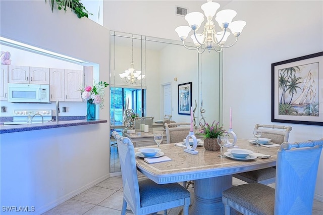 tiled dining space with an inviting chandelier and a high ceiling