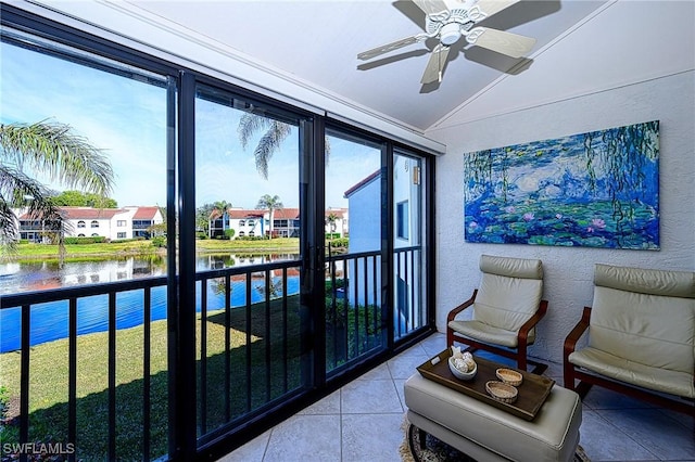 sunroom with a water view, lofted ceiling, and ceiling fan