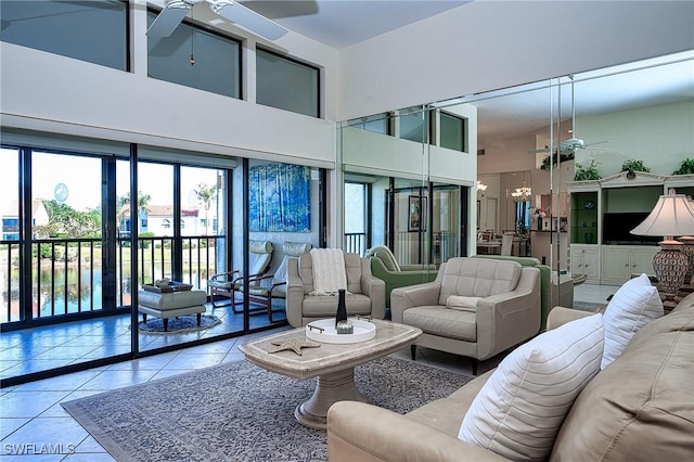 living room featuring light tile patterned floors, a towering ceiling, and ceiling fan