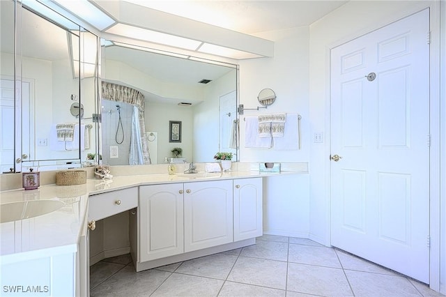 bathroom with tile patterned flooring, vanity, and a shower