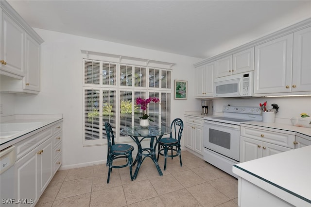 kitchen with white appliances, sink, light tile patterned floors, and white cabinets