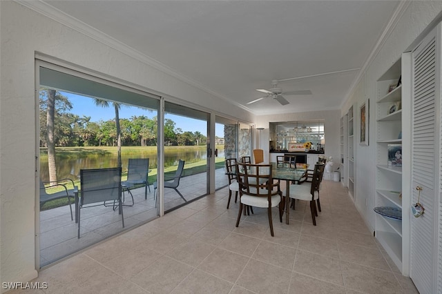 sunroom with a water view and ceiling fan