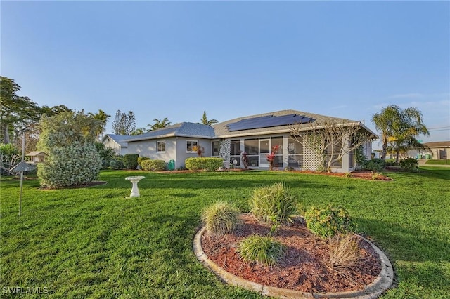 exterior space with a yard, a sunroom, and solar panels