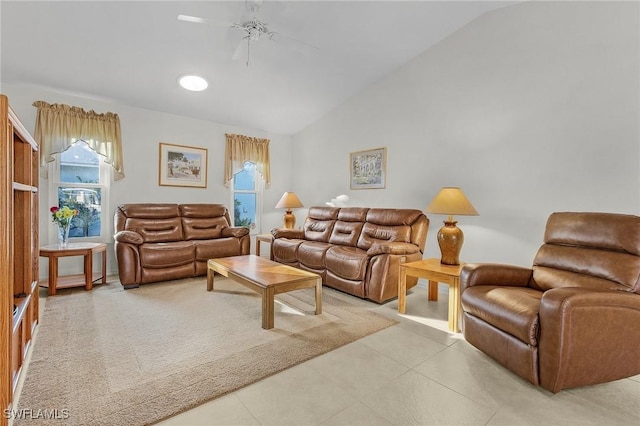 tiled living room featuring ceiling fan, lofted ceiling, and plenty of natural light