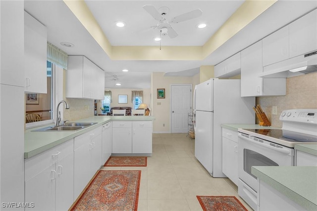 kitchen with sink, white cabinetry, light tile patterned floors, a raised ceiling, and white appliances