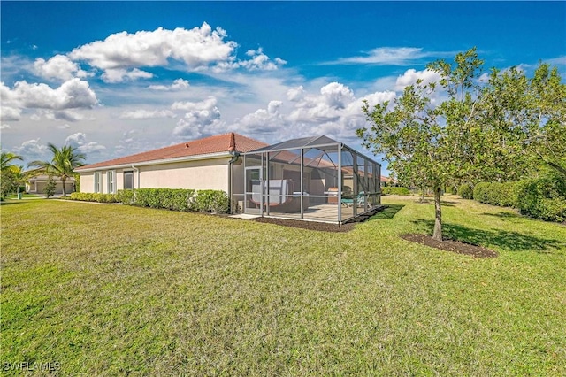 rear view of house with a yard, a patio, and glass enclosure