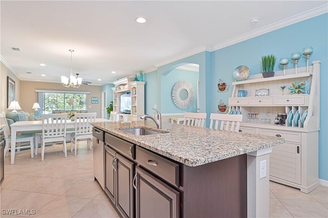 kitchen with sink, a kitchen island with sink, dark brown cabinetry, decorative light fixtures, and stainless steel dishwasher