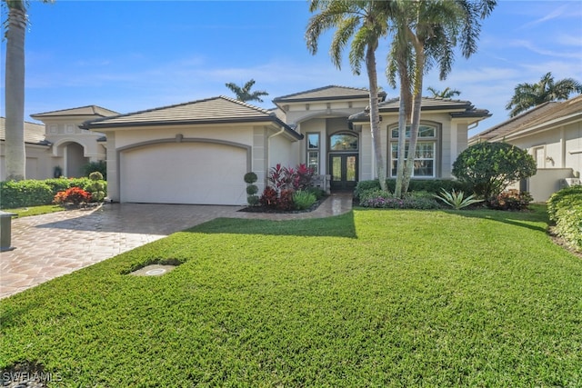 mediterranean / spanish house featuring a garage and a front yard