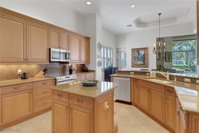 kitchen featuring pendant lighting, appliances with stainless steel finishes, sink, and a kitchen island