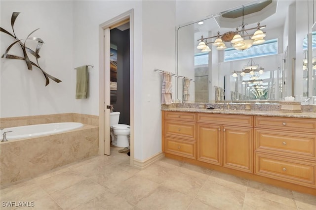 bathroom featuring vanity, a relaxing tiled tub, toilet, tile patterned floors, and an inviting chandelier