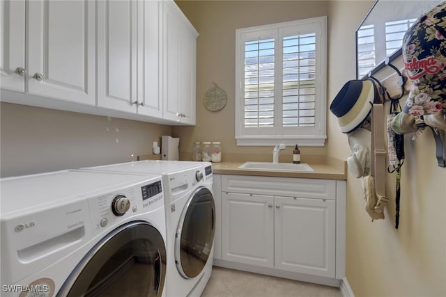 laundry area with cabinets, washer and dryer, and sink