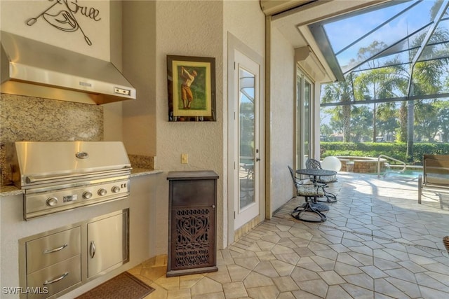 view of patio with an in ground hot tub, an outdoor kitchen, area for grilling, and glass enclosure