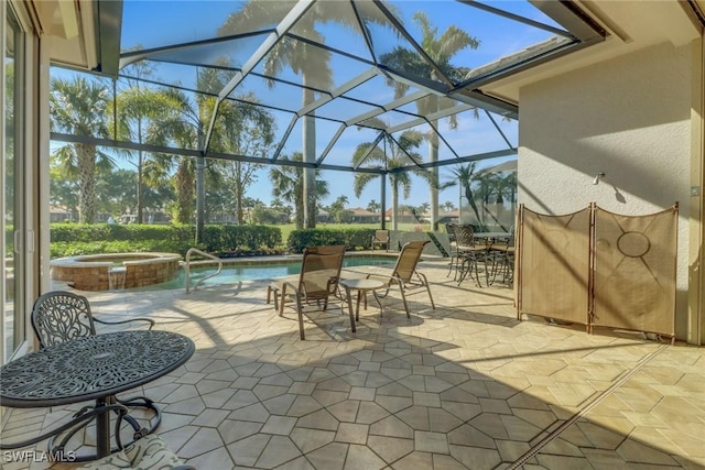 view of patio / terrace featuring a pool with hot tub and glass enclosure