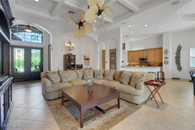 living room with a high ceiling, coffered ceiling, light tile patterned floors, and french doors