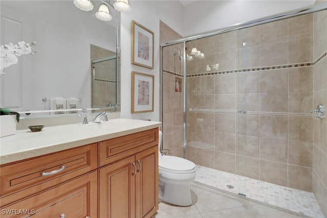 bathroom featuring vanity, a shower with shower door, tile patterned floors, and toilet