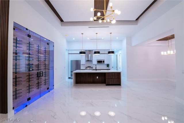 kitchen with a large island with sink, hanging light fixtures, a notable chandelier, and stainless steel appliances