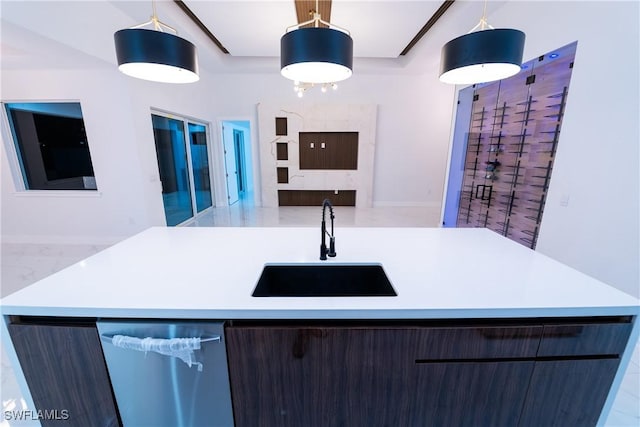 kitchen with sink, decorative light fixtures, and an island with sink