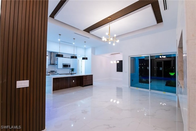 kitchen featuring sink, decorative light fixtures, a center island, appliances with stainless steel finishes, and a notable chandelier