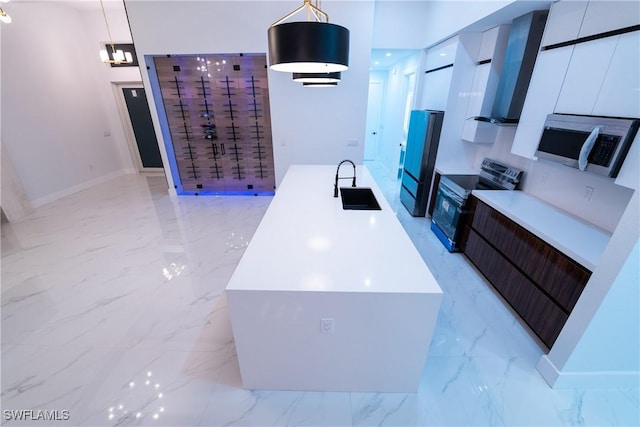 kitchen with sink, decorative light fixtures, wall chimney exhaust hood, and appliances with stainless steel finishes