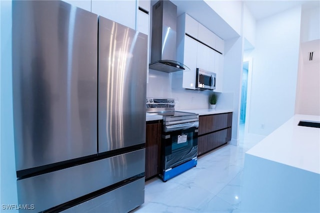 kitchen with white cabinetry, wall chimney exhaust hood, and appliances with stainless steel finishes