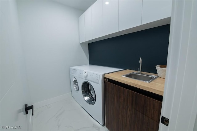 laundry area featuring sink, washer / dryer, and cabinets